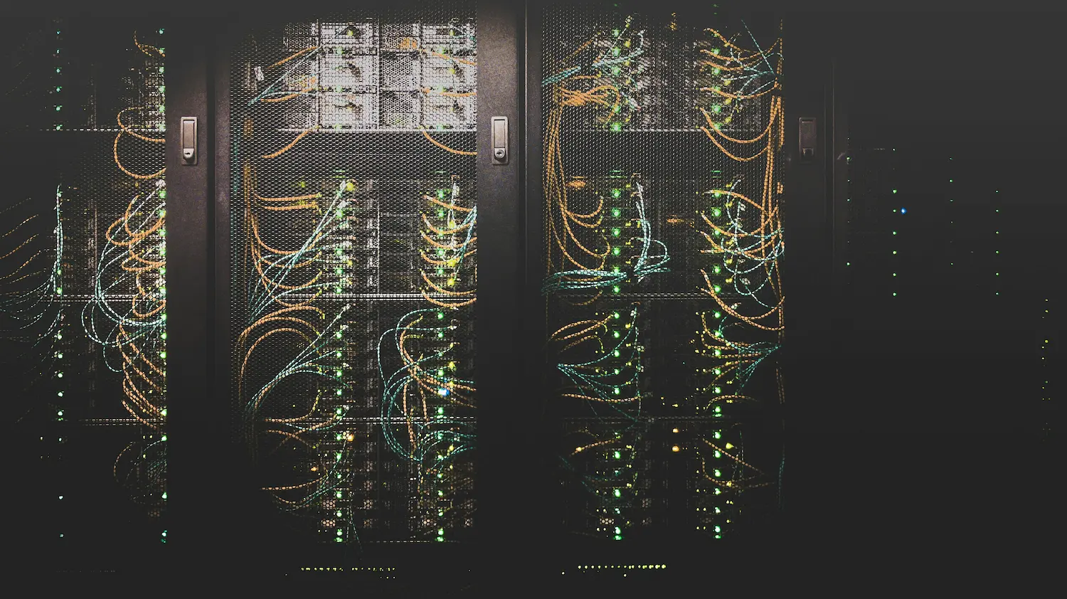 Server racks filled with network cables and blinking lights in a data center.